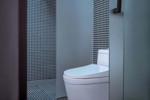 a bathroom with a white toilet and a shower at 山也云也大理古城南门店 in Dali Ancient Town