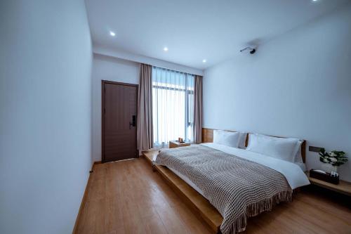 a bedroom with a large bed and a large window at 山也云也大理古城南门店 in Dali Ancient Town