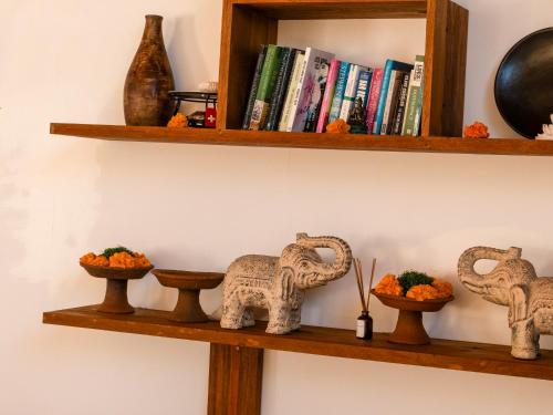 a shelf with two elephants and some books at Sukacita Hill in Uluwatu