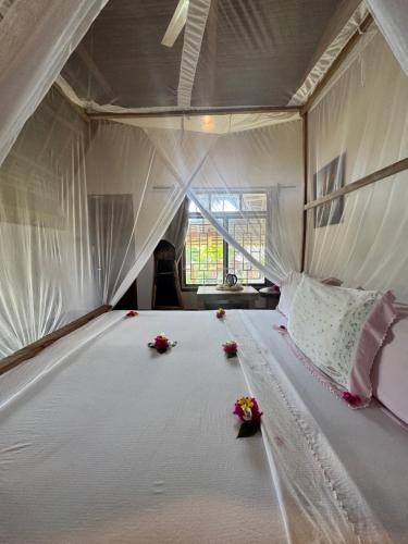 a white bed in a room with flowers on it at Jumanji B&B in Kinyasini