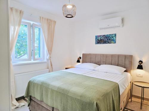 a bedroom with a large bed with a green blanket at Mare`s Private House 1st floor with Pool in Karlobag
