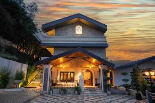 a house with a sunset in the background at Virgin Valley Leisure Resort in Ooty