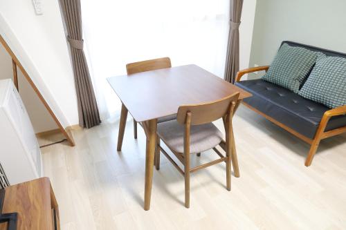 a dining room table and chair with a couch at シティラデファンス - 2025年6月室内リニューアル in Sapporo