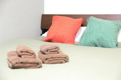 a bed with two folded towels on top of it at シティラデファンス - 2025年6月室内リニューアル in Sapporo