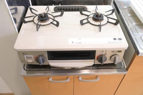 a white stove top oven sitting in a kitchen at シティラデファンス - 2025年6月室内リニューアル in Sapporo