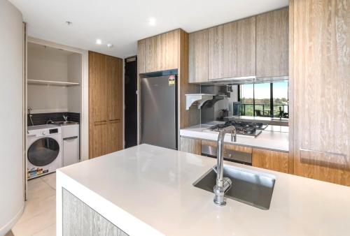 a kitchen with a sink and a refrigerator at 108 Flinders - Stunning Views & Prime Location in Melbourne