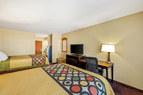 a hotel room with two beds and a desk and a bed sidx sidx at Super 8 by Wyndham Marana/Tucson Area in Tucson
