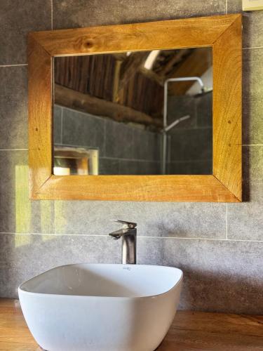 a white sink in a bathroom with a mirror at Jumanji B&B in Kinyasini