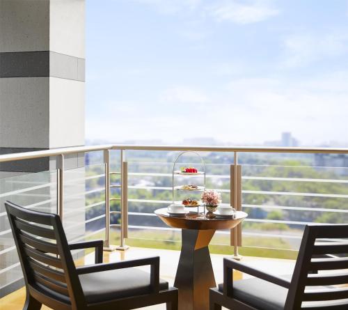 a table and two chairs on a balcony at Grand Hyatt Mumbai Hotel and Residences in Mumbai