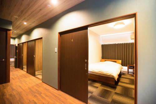 a bedroom with a bed and a large mirror at ファーストアベニューハウス 駅近 1組限定貸切 in Anan