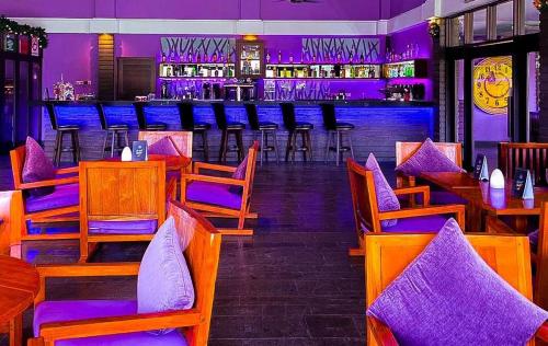 a bar with wooden chairs and a bar with purple lights at Cyberview Resort & Spa in Cyberjaya