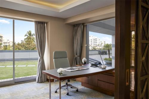 an office with a desk and a window at Grand Hyatt Mumbai Hotel and Residences in Mumbai