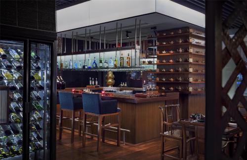 a bar in a restaurant with blue bar stools at Grand Hyatt Mumbai Hotel and Residences in Mumbai