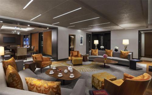 a lobby with couches and chairs and a table at Grand Hyatt Mumbai Hotel and Residences in Mumbai