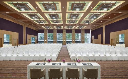 a room with rows of white chairs and tables at Grand Hyatt Mumbai Hotel and Residences in Mumbai