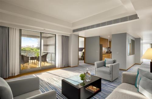 a living room with a couch and a table at Grand Hyatt Mumbai Hotel and Residences in Mumbai