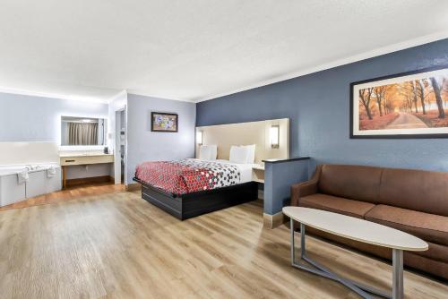 a hotel room with a bed and a couch at Econo Lodge Inn & Suites Cayce I-26 Airport in Cayce
