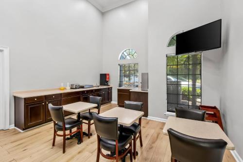 a dining room with tables and chairs and a kitchen at Econo Lodge Inn & Suites Cayce I-26 Airport in Cayce