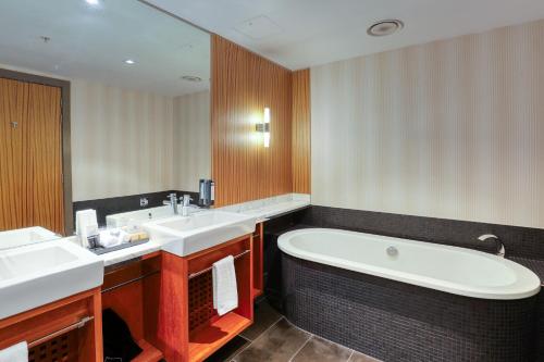 a bathroom with two sinks and a bath tub at Marsden Viaduct in Auckland
