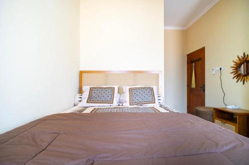 a bedroom with a bed with two pillows on it at Joglo Prambanan A4 in Bugisan