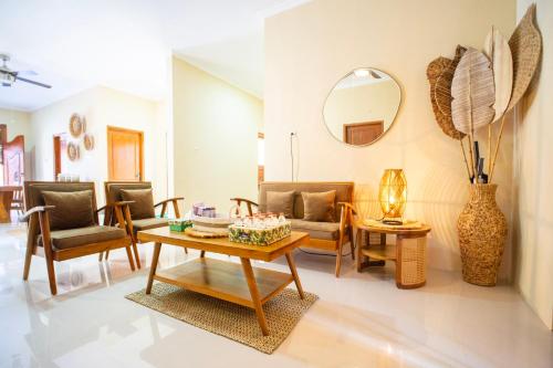 a living room with a table and chairs and a mirror at Joglo Prambanan A4 in Bugisan