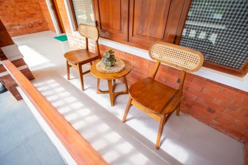 a porch with three chairs and a table and a window at Joglo Prambanan A4 in Bugisan