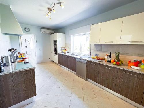 a kitchen with wooden cabinets and a counter top at Stunning Casa Nicole by Be Cherish in Pêra