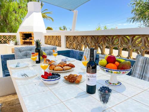 a table with a bunch of food and a bottle of wine at Stunning Casa Nicole by Be Cherish in Pêra
