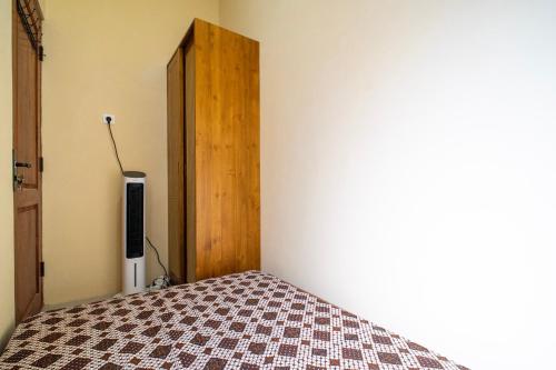 a bedroom with a bed and a wooden door at Joglo Prambanan A4 in Bugisan