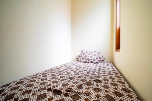 a bed in a room with a pillow on it at Joglo Prambanan A4 in Bugisan