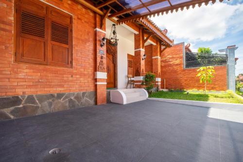 a courtyard of a house with a brick wall at Joglo Prambanan A4 in Bugisan