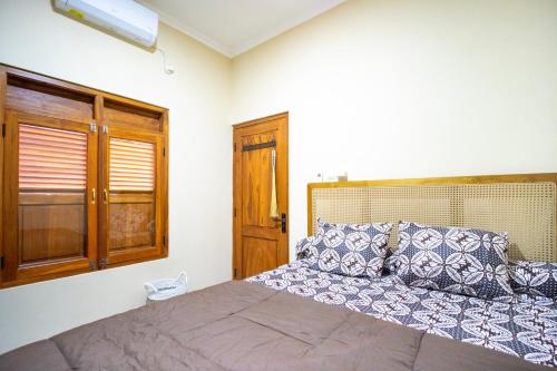 a bedroom with a large bed and a window at Joglo Prambanan A4 in Bugisan