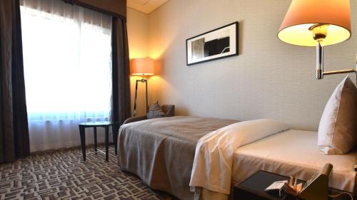 a hotel room with a bed and a window at Okura Chiba Hotel in Chiba