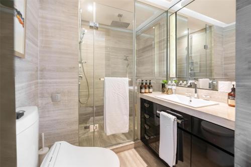 a bathroom with a shower and a toilet and a sink at Kempinski The One Suites Hotel Shanghai Downtown in Shanghai