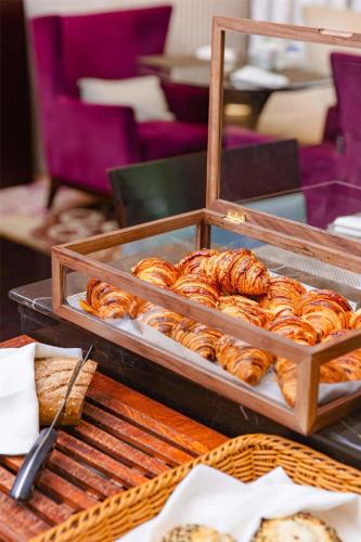 a bunch of croissants and other pastries on a buffet at Kempinski The One Suites Hotel Shanghai Downtown in Shanghai