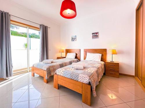 een slaapkamer met twee bedden en een groot raam bij AlbufeiraOrada Garden by Be Cherish in Albufeira
