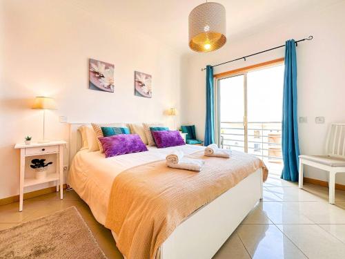 una camera da letto con un letto grande con asciugamani sopra di AlbufeiraOrada Cozy&Sunny Condo by BeCherish ad Albufeira