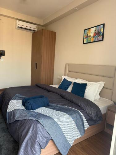 a bedroom with a large bed with blue pillows at Nirvana by Urban Retreat Suite Near Expo Mart in Greater Noida