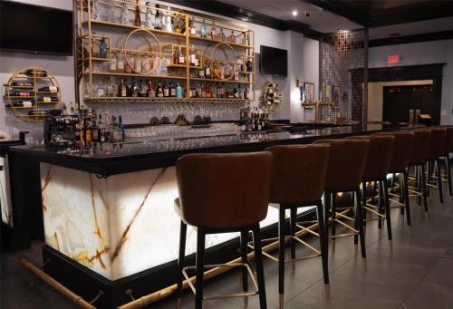 a bar with a row of brown bar stools at The Roslyn, Tapestry Collection by Hilton in Roslyn