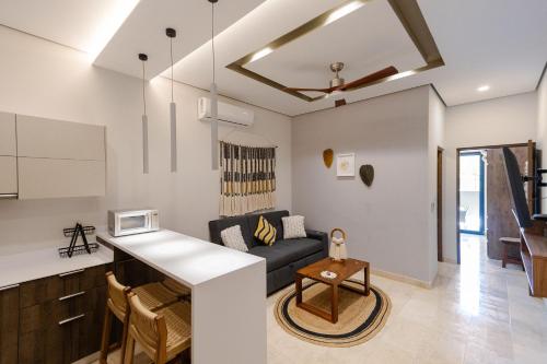 a kitchen and living room with a couch and a table at Apartment with Private Jacuzzi, Rooftop Pools & Free beach club in Tulum