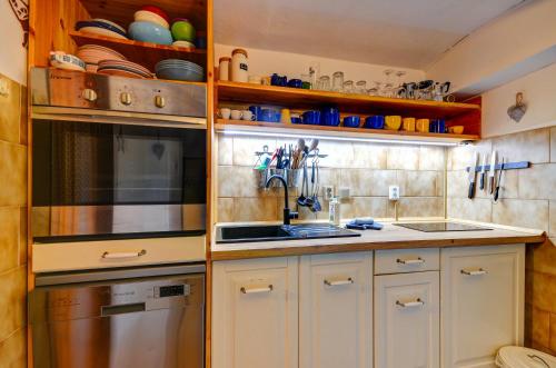a kitchen with white cabinets and a stainless steel appliance at Chalupa v Meziluzi in Meziluží