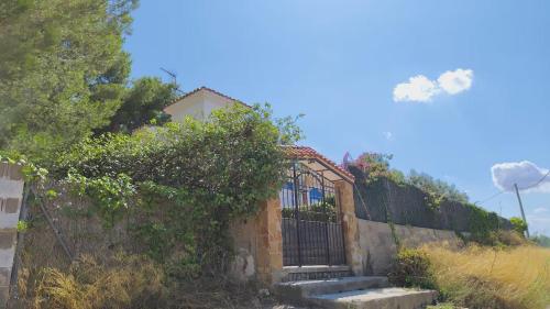 a gate on the side of a house at Buenas vistas y privacidad, tranquila y fresca villa en el bosque de Valencia con una magnífica piscina de 80m2 in Lliria