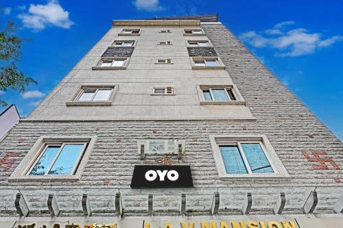 ein hohes Gebäude mit einem Schild davor in der Unterkunft Collection O The Mass Residency By Dv in Bangalore