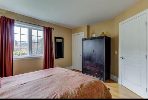 a bedroom with a bed and a dresser and a window at In-ground pool - Spacious condo - Horizons in Saint-Sauveur-des-Monts
