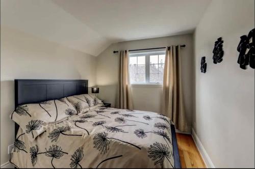 a bedroom with a bed with a comforter and a window at In-ground pool - Spacious condo - Horizons in Saint-Sauveur-des-Monts
