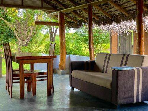 a living room with a couch and a table and a chair at The Happy House Nature Retreat in Talakolawela