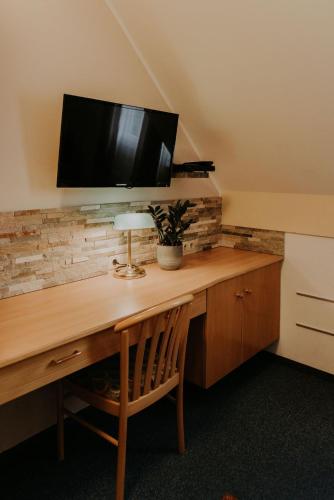 a desk with a television on top of a wall at Restaurant Gästehaus Feldkirchen in Feldkirchen bei Graz
