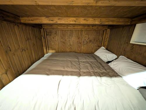 a bed in a wooden room with two pillows at 17minutes by car to Nagoya-Sta 1parking in Chiharachō
