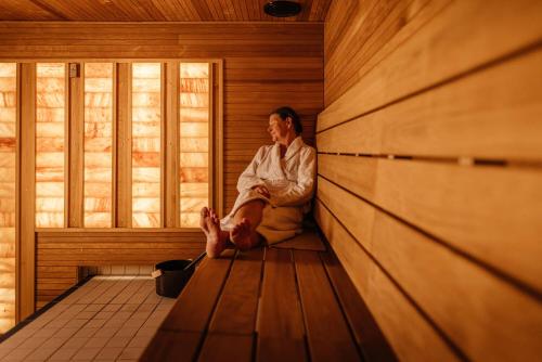 a man sitting on the floor in a sauna at Holiday Club Vierumäki in Vierumäki