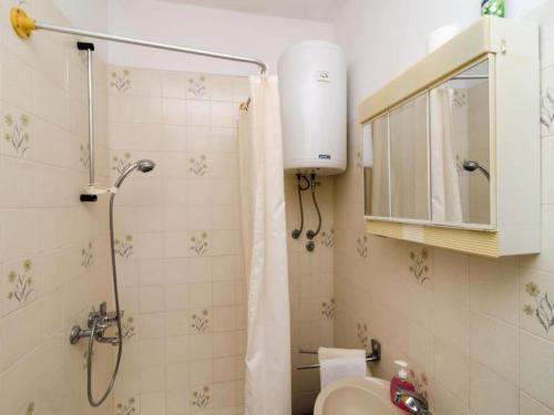 een badkamer met een douche, wastafel en toilet bij Apartments Anka - One-Bedroom Apartment with Balcony and Sea View in Trsteno